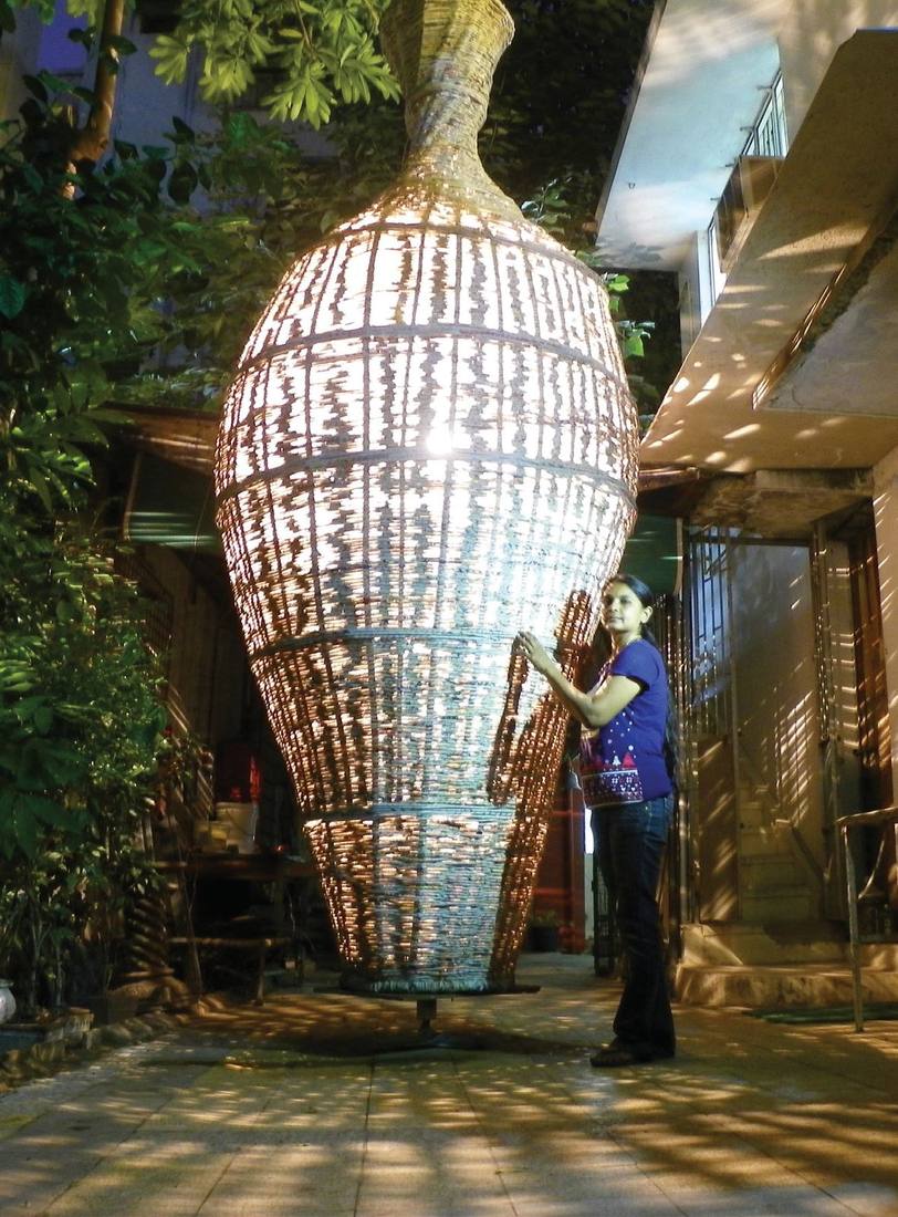 Neelu Patel working on the 16-foot paper-stick pot at night