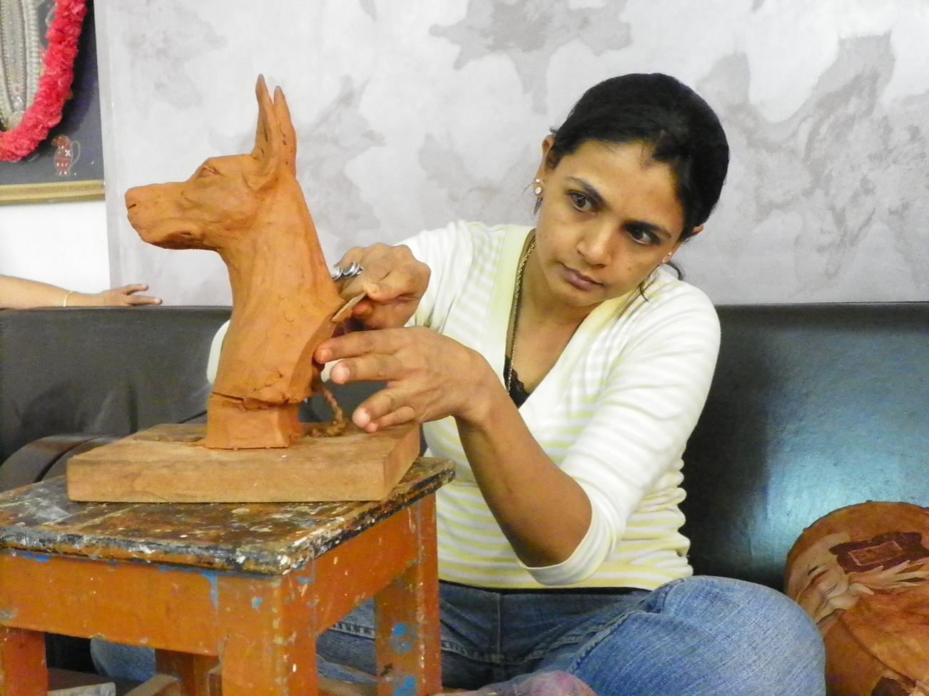 Shaping a dog head in clay